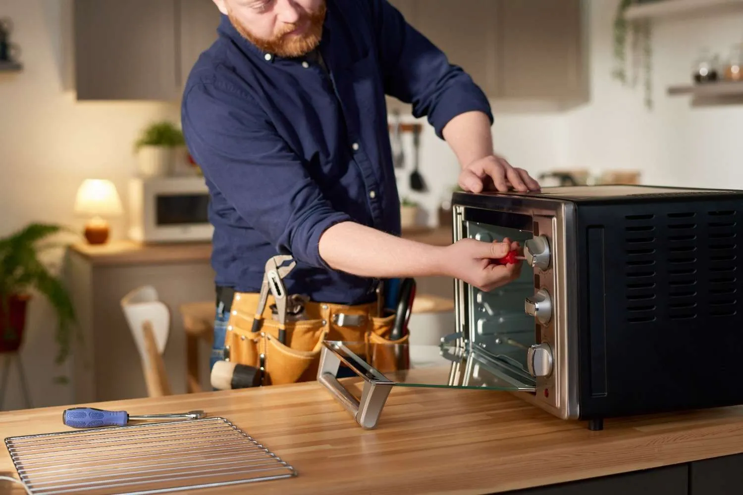 Technician checking a countertop oven in a home kitchen